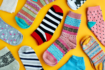 Multi-colored socks on a bright background. View from above. Striped, blue, pink, patterned socks...
