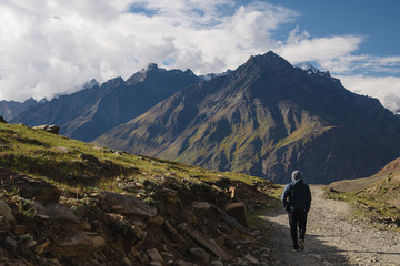 Fototapeta na wymiar a man walking on empty road with mountain view