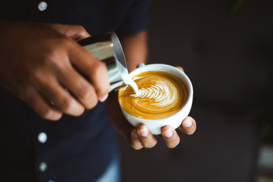 Fototapeta Barista making a cup of coffee latte art in coffee shop..