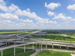 Horizontal aerial view Interstate 10 or Katy freeway massive intersection, stack interchange, elevated road junction overpass in daytime cloud blue sky. Aerial metropolitan area of Katy, Texas, USA - obrazy, fototapety, plakaty