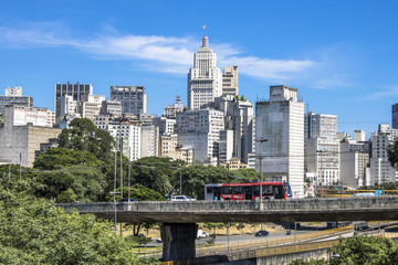 Fototapeta na wymiar Sao Paulo, Brazil, February 23, 2017. Traffic on Estado Avenue and skyline of downtown Sao Paulo on sunny day