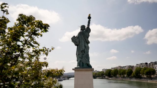 Time lapse in Paris of a Statue of Liberty. The statue is smaller than the one in New York. It is located on a small island in the Seine. Back view. 