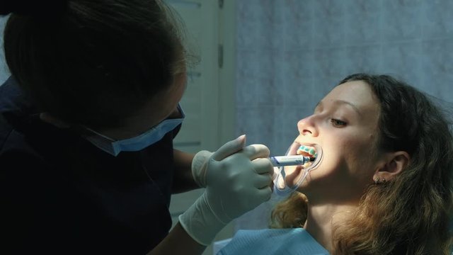 Orthodontist applies the gel on the teeth before installing the bracket system. Visit to the dentist