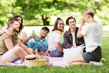 friendship, leisure and technology concept - group of happy smiling friends with non alcoholic...