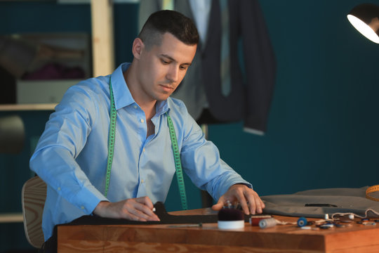 Young Tailor Marking Fabric With Chalk In Atelier