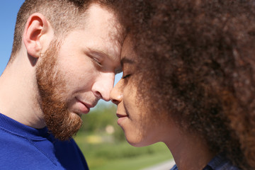 Obraz premium Young loving interracial couple outdoors on spring day