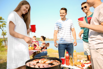 Young people having barbecue party on sunny day outdoors