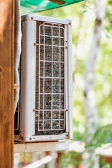 Close-up outdoor air condition unit with clogged obstructed compressor radiator grill. Details of...