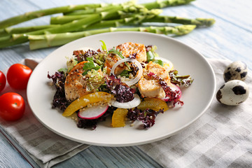 Plate with tasty chicken salad on wooden table