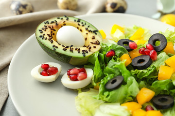 Plate with tasty avocado salad on table, closeup
