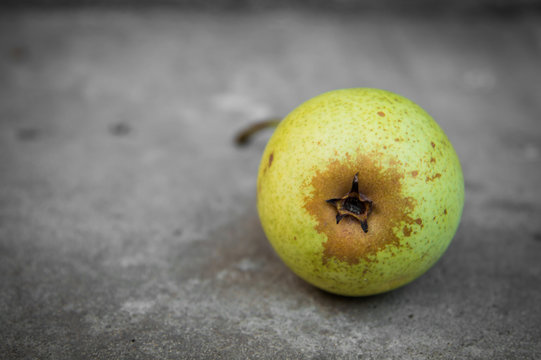 Yellow pear on grey concrete background
