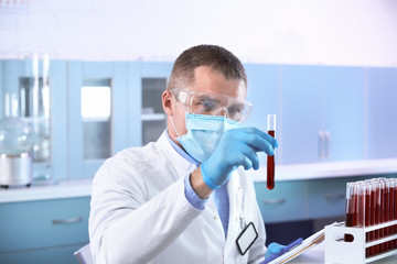 Fototapeta na wymiar Scientist holding test tube with blood sample in laboratory