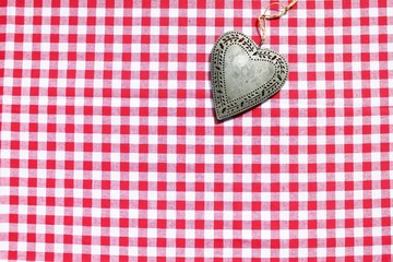 Rustikales Metallherz auf karierter Tischdecke, Oktoberfestmotiv