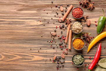 Composition with different dry spices on wooden background