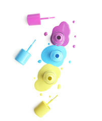 Open bottles of nail polishes with brushes on white background