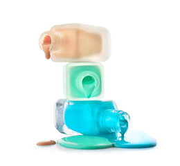 Open bottles of nail polishes on white background