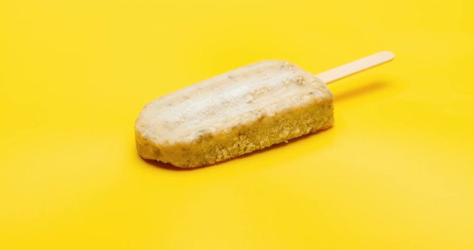 reverse of studio shoot of green bean popsicle melting time lapse on yellow background