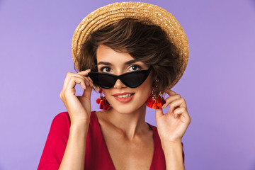 Pretty brunette woman in dress, straw hat and sunglasses