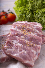 Uncooked  ribs with  vegetables on crumpled paper.