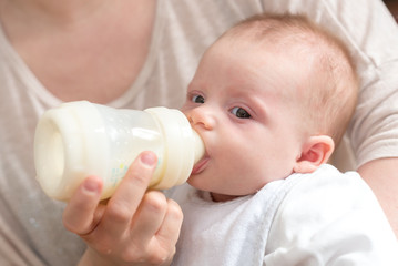 Baby drinking milk from feeding bottle