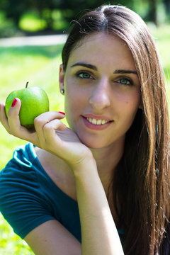 Young woman smiling holding an apple