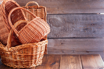 Woven empty baskets from natural handmade vines for mushrooms, handicrafts, storage, walks, picnic on a wooden table, copy space