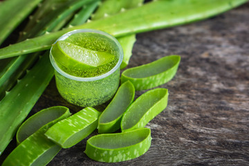 fresh green aloe vera leaves slice and aloe vera gel on wooden table 