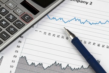 Pen And Calculator On Financial Graphs Close-up