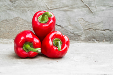 Ripe red peppers on grey concrete background