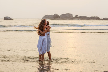 two sisters having fun at the sea at the sunset