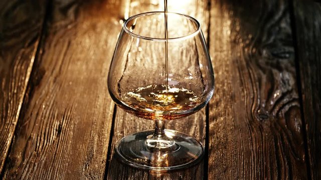 Cinematic UHD shot of cognac pouring into the glass