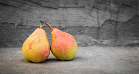 Ripe yellow pears on grey concrete background © mariyakuprevich