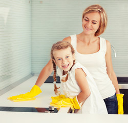 Mother with child washing kitchen