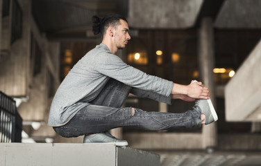 Young man practicing yoga in the city