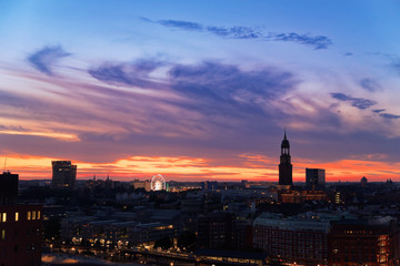 Hamburg at sunset. Dancing Towers, Ferris Wheel of Hamburg's Dom and St. Michael's church in a distant