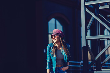 Stylish fashion portrait of brunette woman in hat. Posing in the city. copy space