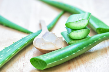 Fresh aloe vera leaves with aloe vera juice in bottle on wooden background