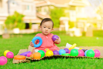 Obraz premium Cute Asian baby playing with toys in playground 