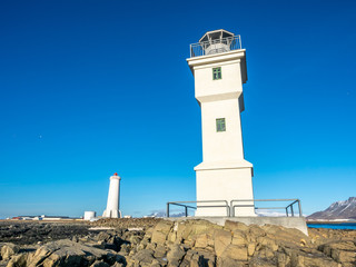 Fototapeta na wymiar The old inactive Akranes lighthouse at end of peninsula in city, was built since 1918, under blue sky, Iceland
