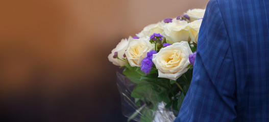 Man holding bouquet of roses and blue stasis