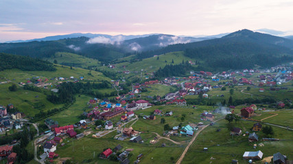 Fototapeta na wymiar Village in the mountains from a bird's eye view during sunset