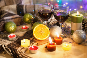 Two glasses of wine with candles in the New Year decorations. Christmas background.