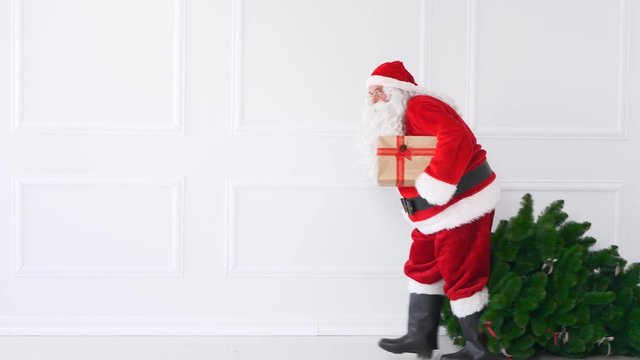 Tired santa claus with christmas tree and christmas present
