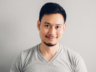 Headshot photo of Asian man with happy face. on grey background.