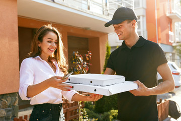 Pizza Delivery. Courier Giving Woman Boxes With Food Outdoors