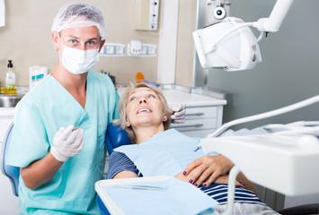 Male dentist with female patient during checkup