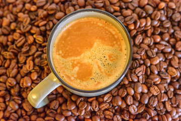 a cup of coffee on a background of coffee beans