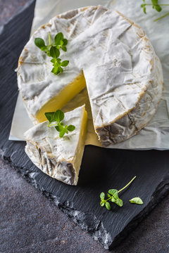 Cheese camambert from oregano herbs on slate board