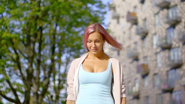 Slow motion portrait of Caucasian slender girl with pink hair in the city of real people series