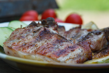 Grilled juicy pork chops with fresh tomato and cucumber salad